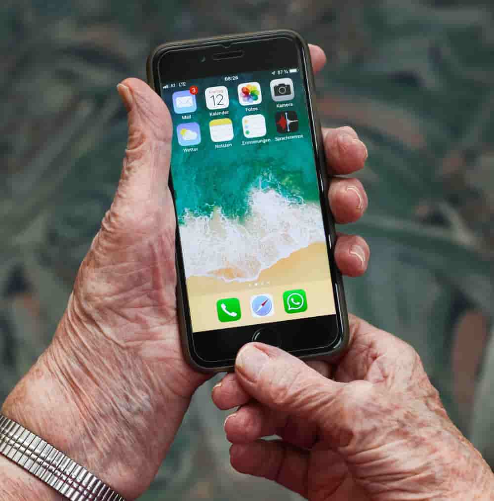 Ältere Person hält Handy in der Hand